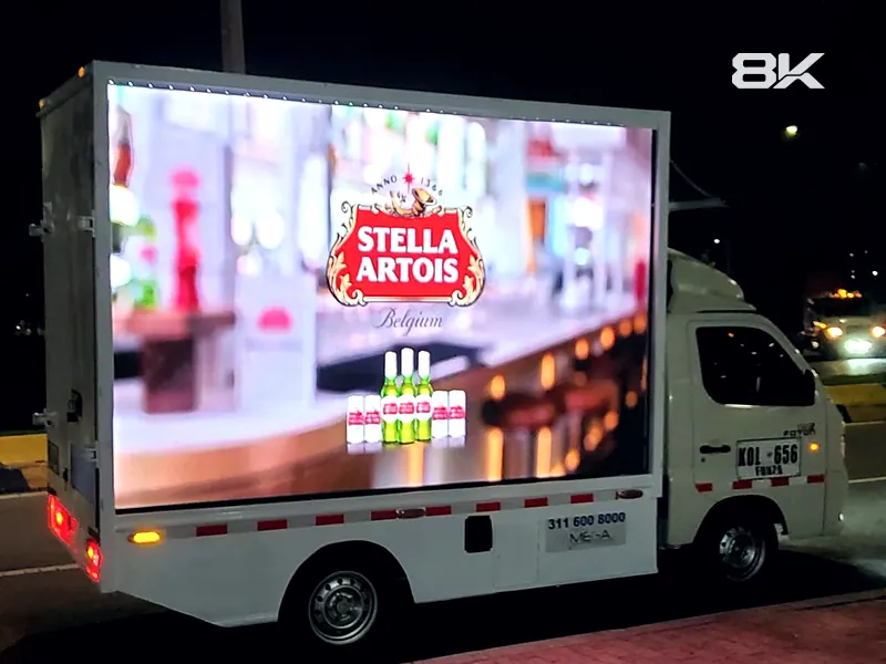 Camión con pantalla LED mostrando publicidad de noche