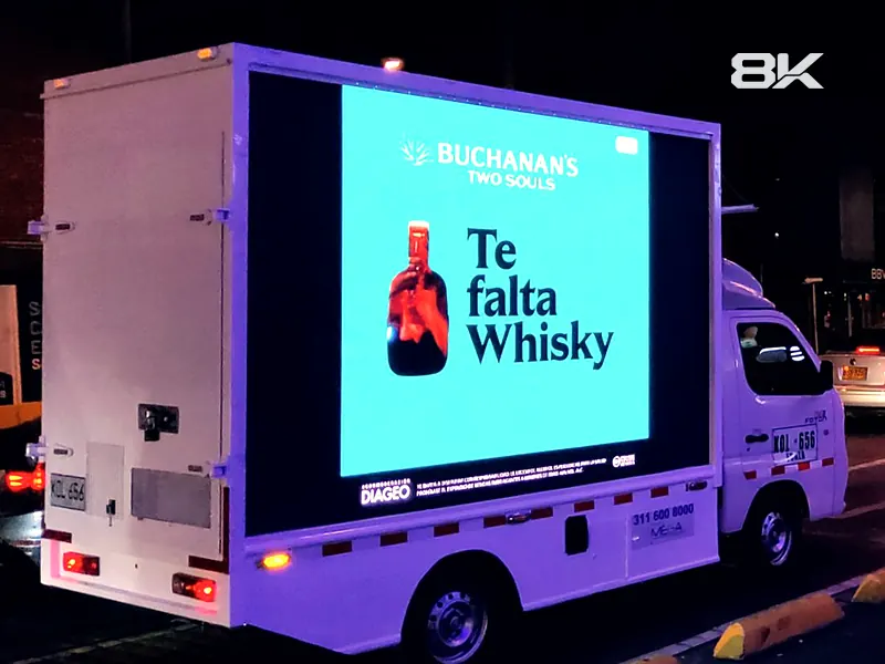 Carro valla LED con publicidad iluminada en una calle de Bogotá de noche