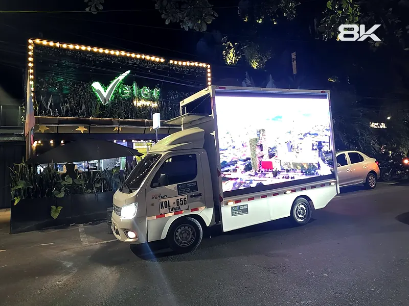 Carro valla LED encendido de noche frente a un restaurante