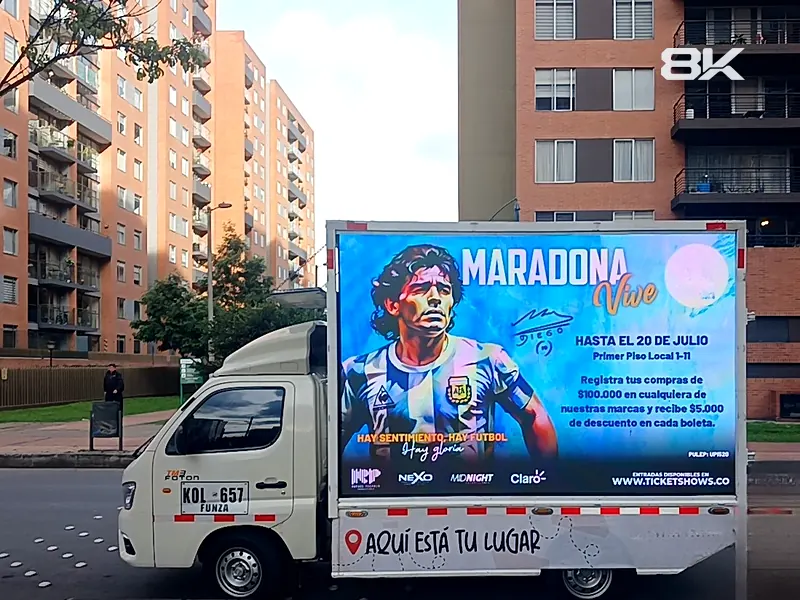 Carro valla LED con la promoción de un evento estacionado en una calle residencial