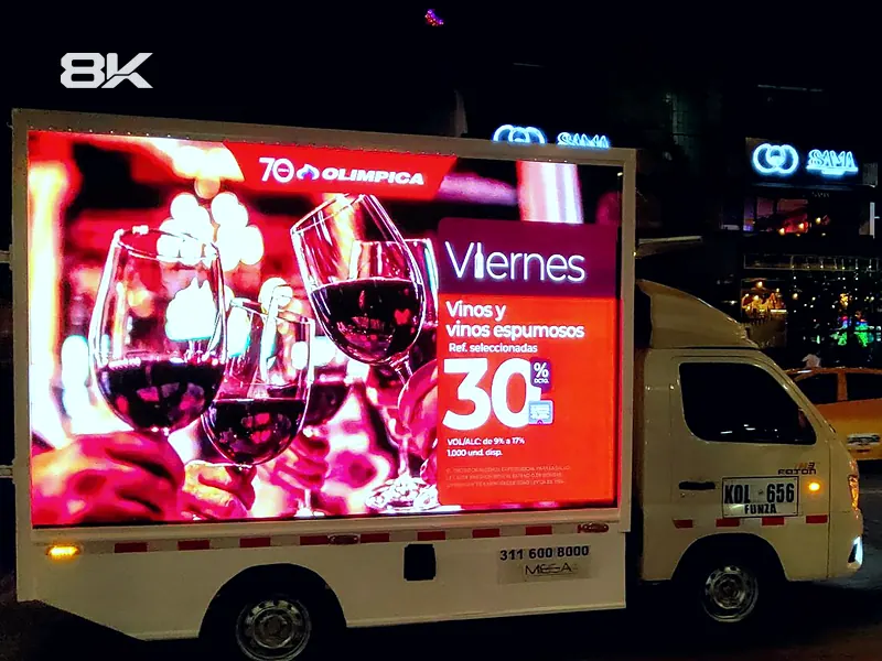 Vista lateral de un carro valla LED con una promoción de vinos