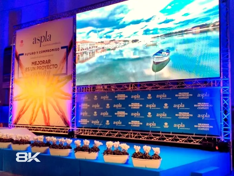 Pantalla LED sobre estructura truss junto al backing de un evento empresarial