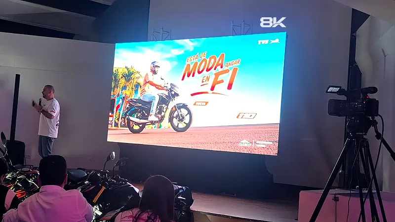 Lanzamiento de motocicletas con presentador frente a una pantalla LED y cámara de video