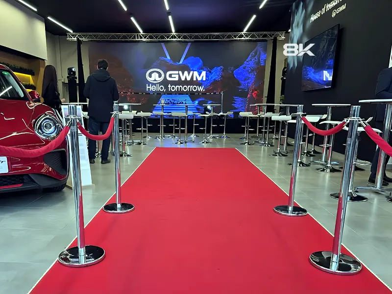 Lanzamiento de vehículo en concesionario con pantalla LED al fondo de la alfombra roja