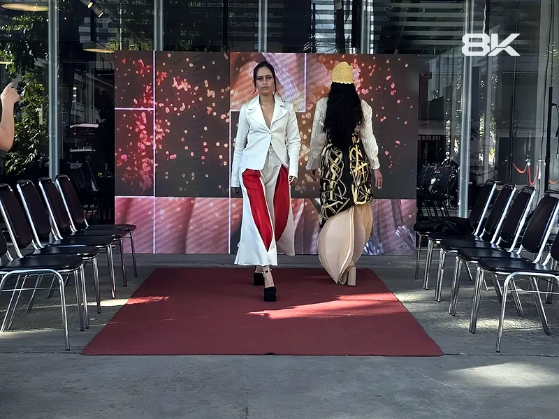 Desfile de moda con pantalla LED de fondo y pasarela con alfombra roja