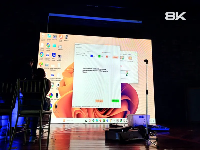 Pantalla LED encendida en un salón oscuro durante la configuración técnica previa al evento