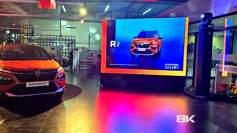 Camioneta exhibida en un showroom junto a una pantalla LED con su imagen