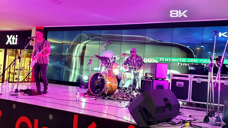 Banda en vivo en una tarima de centro comercial con video wall LED de fondo