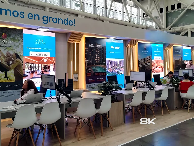 Stand de feria con tótems LED verticales mostrando contenido de marca